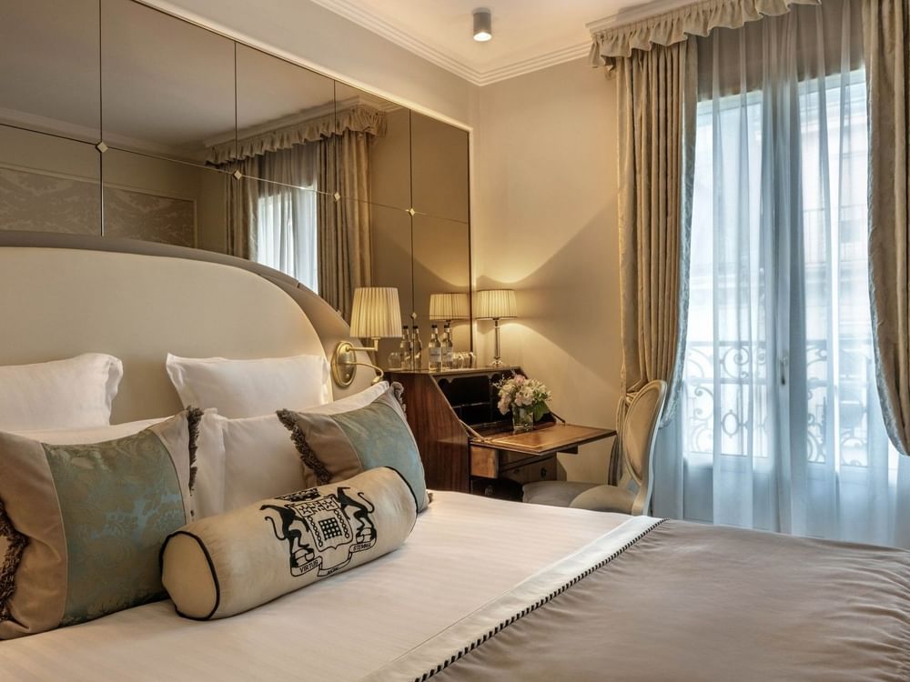 Bed under hanging wall lamp and work desk near window in Superior Single Room at Hotel Westminster Paris