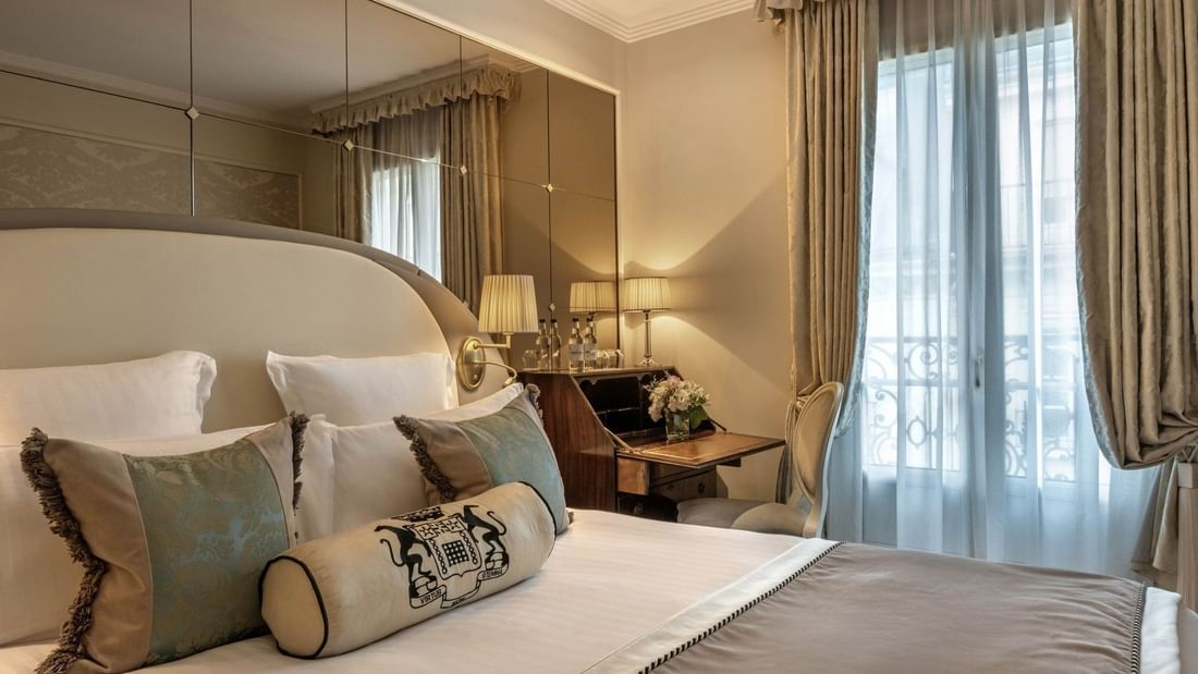 Élégante chambre simple supérieure avec un grand lit, des oreillers à motifs floraux et un bureau raffiné à l'Hôtel Westminster - Paris.