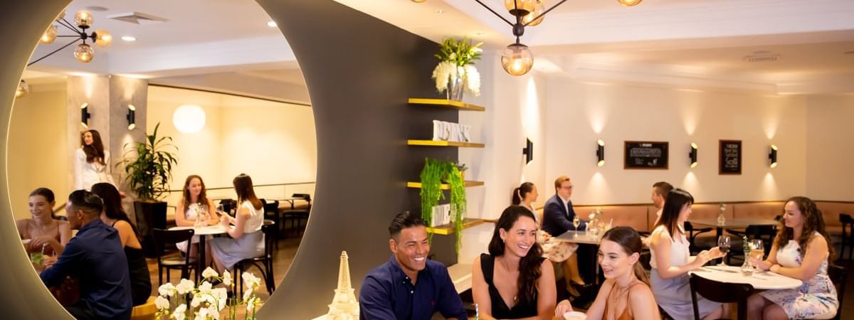 Guests enjoying cocktails and conversation under stylish lighting in the Marke bar at Novotel Sydney International Airport