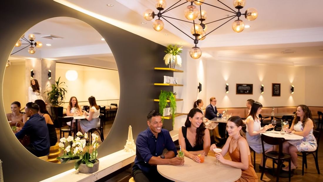 Guests enjoying cocktails and conversation under stylish lighting in the Marke bar at Novotel Sydney International Airport