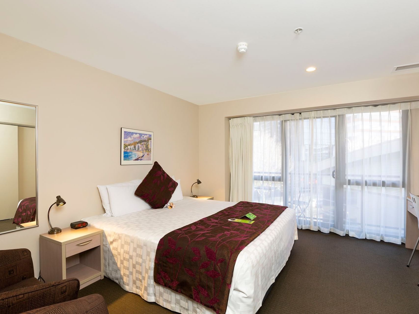 King bed & chairs in Studio Suite with carpeted floors at Hotel Grand Chancellor