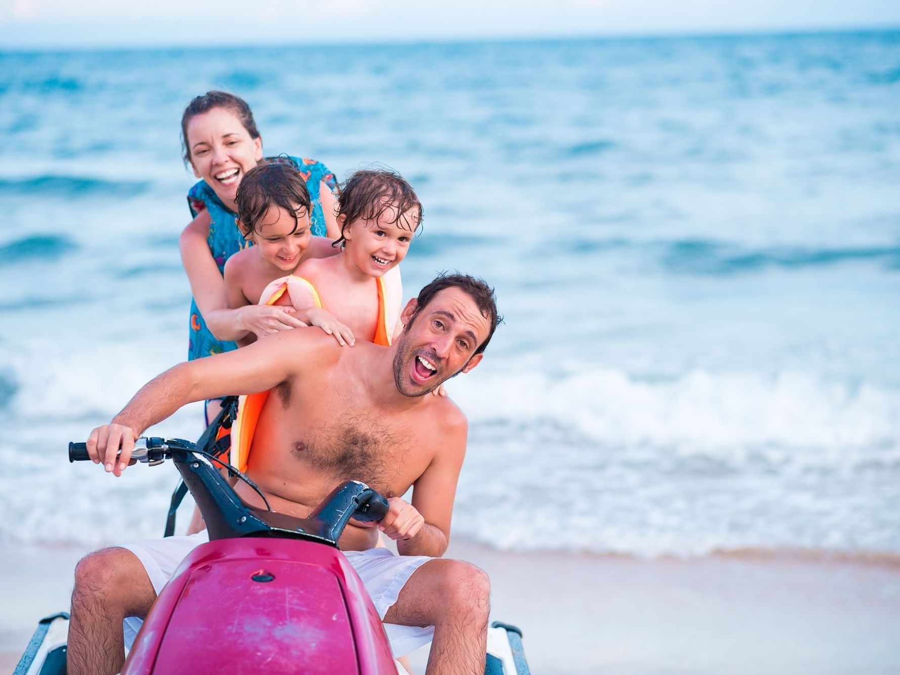 Family on a jet ski at the beach near Daydream Island Resort