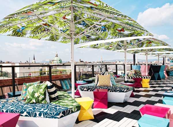 Terrace with colorful umbrellas, black and white floor and colorful seating on the rooftop