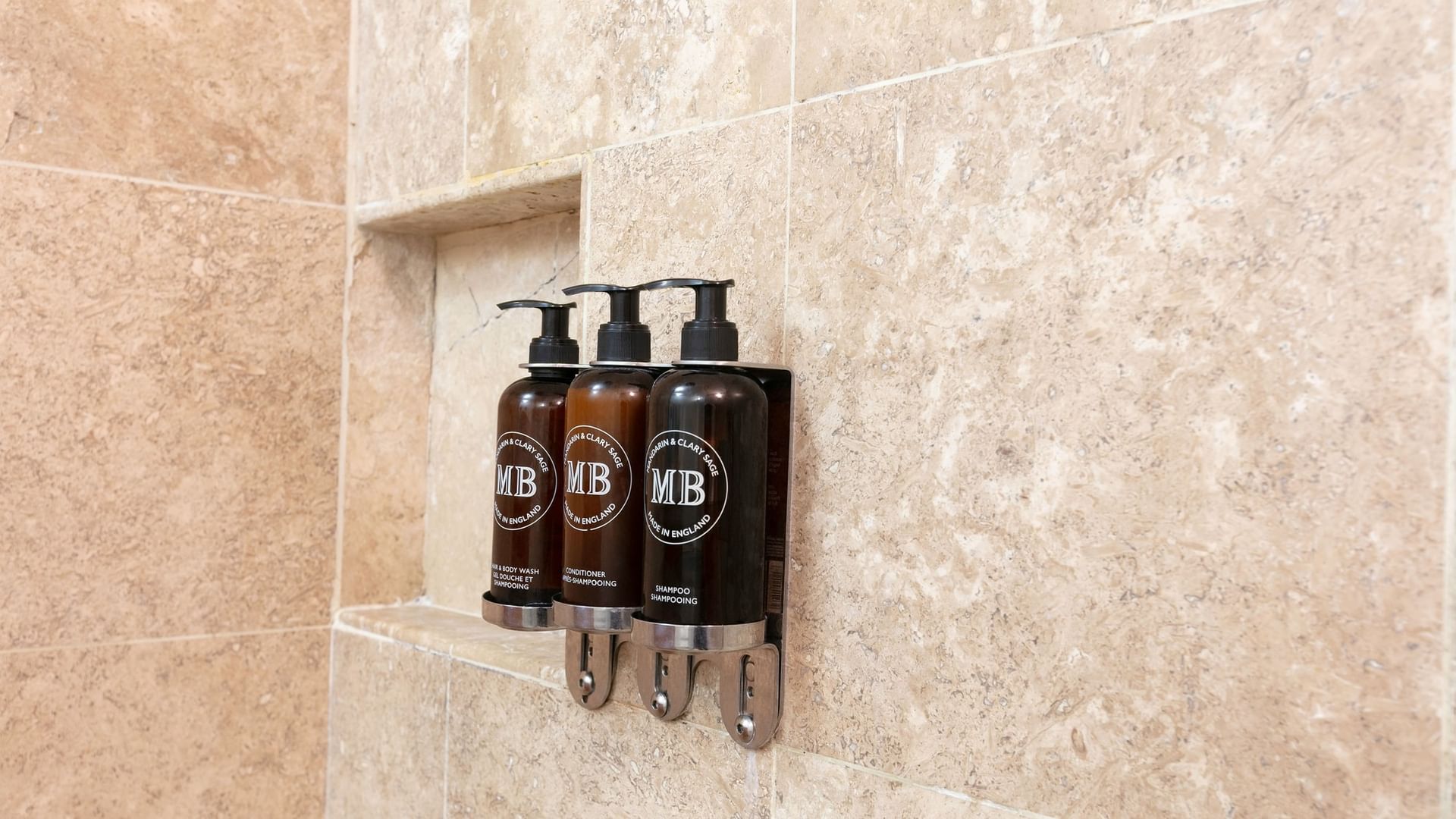 Three MB brand toiletries bottles on tiled wall in King Camino Real Club room at Camino Real Guadalajara in Zapopan
