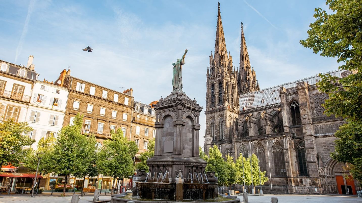 A statue in front of a majestic cathedral near Oceania Hotels