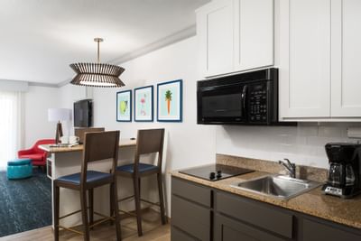 two bar chairs next to a kitchen area