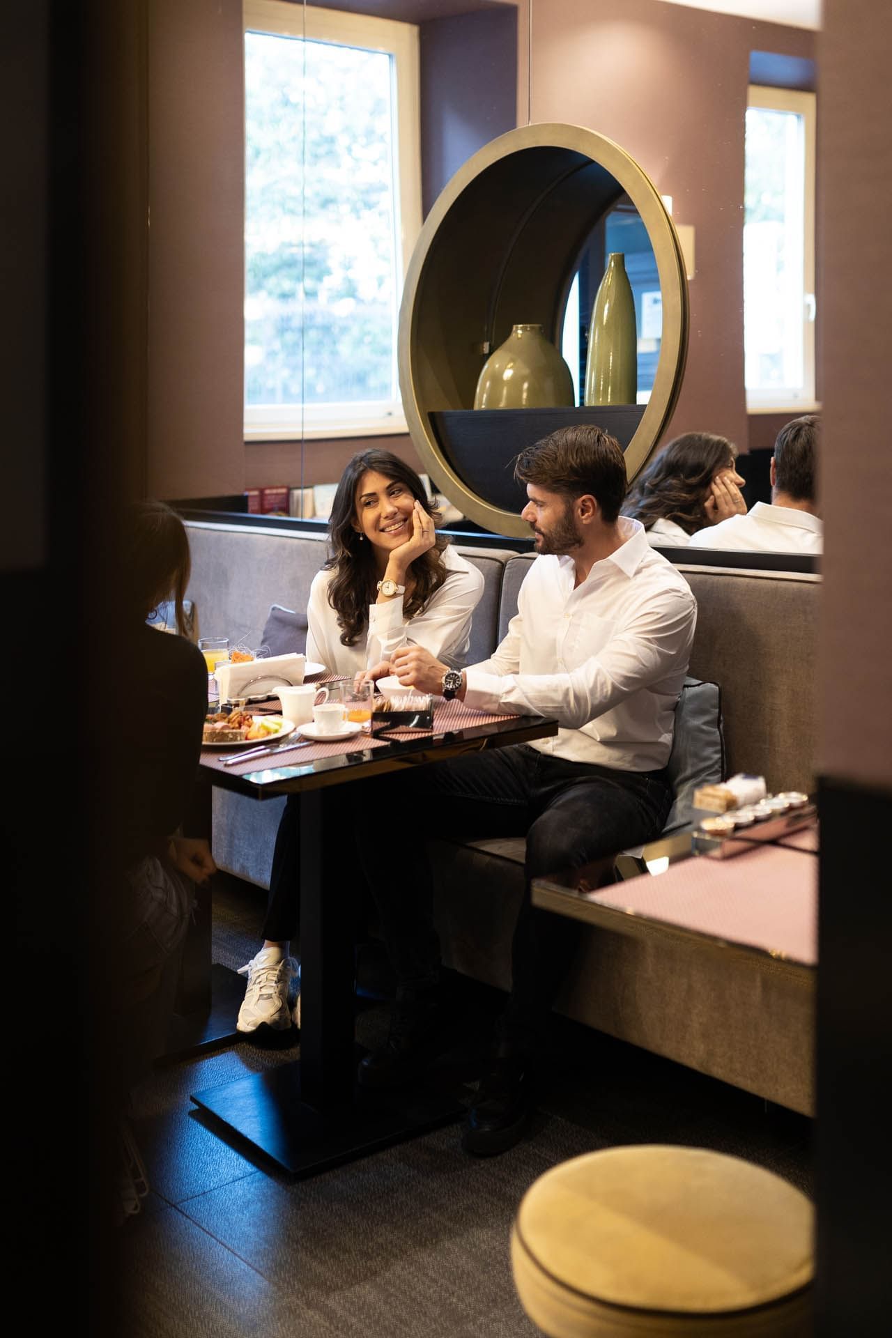 A couple enjoys a meal at a stylish table in a modern restaurant with elegant decor at The Guardian Hotel