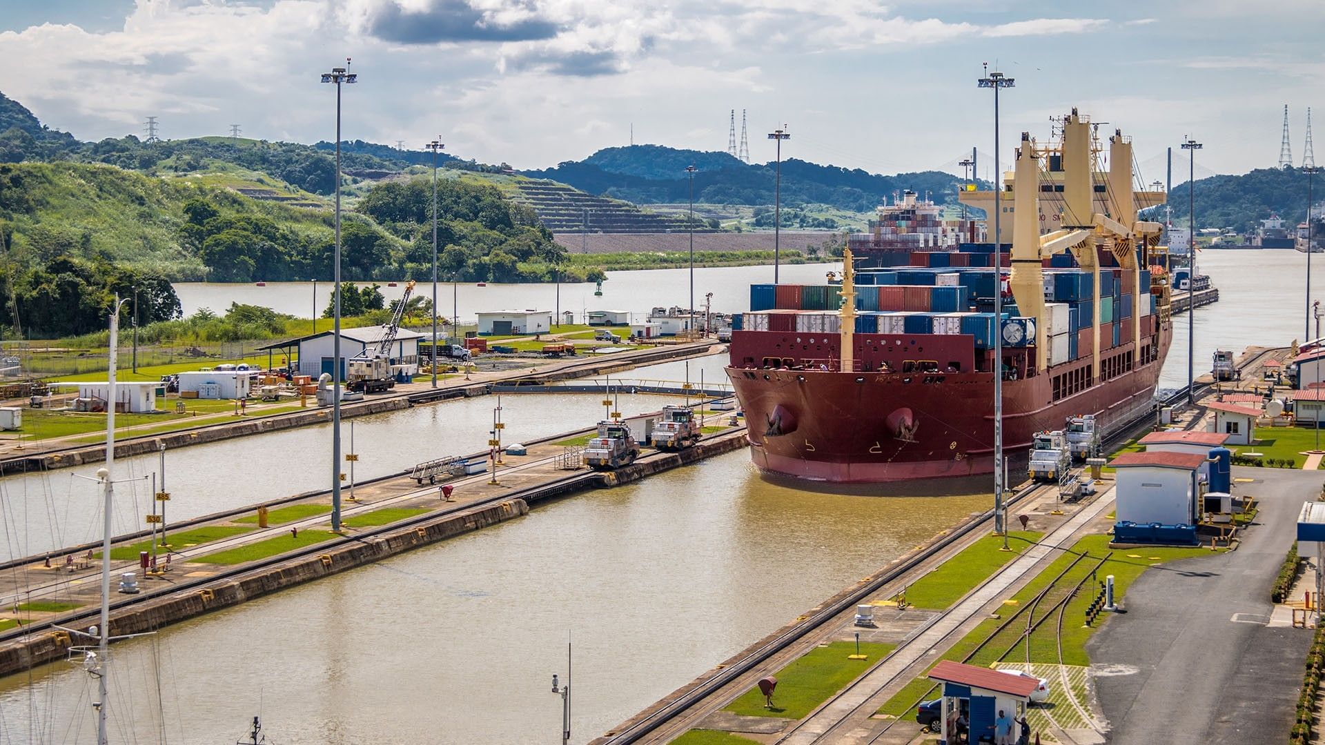 Buque carguero con contenedores navegando por las esclusas del Canal de Panamá en Playa Blanca Beach Resort