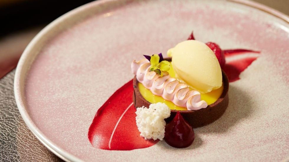 Elegant dessert on a speckled plate & scoop of sorbet in restaurant at  Crown Hotels Perth