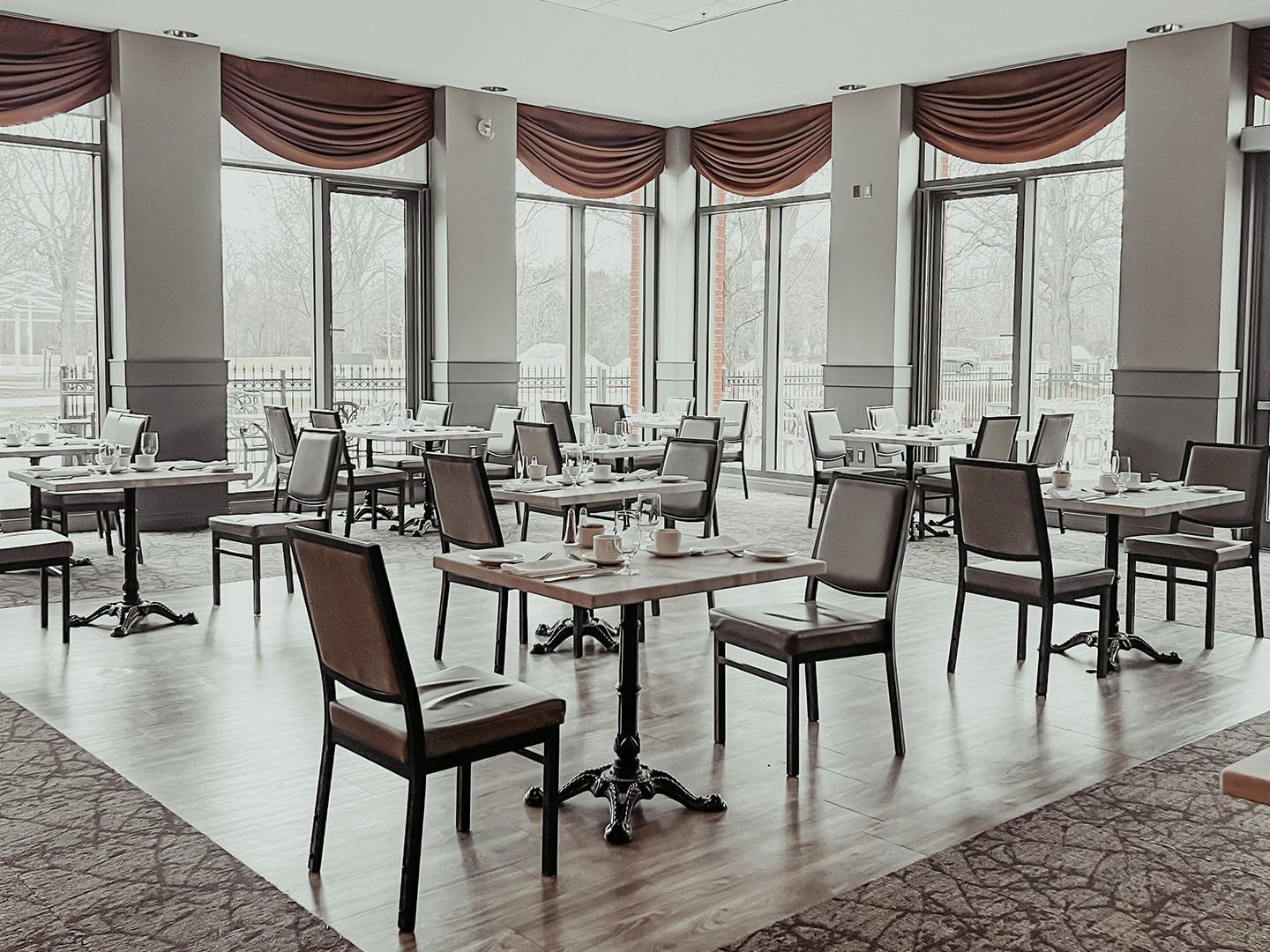 Dining setup in Garden Room with high windows and drapery at Spencer Hotel, one of the best restaurants in London Ontario