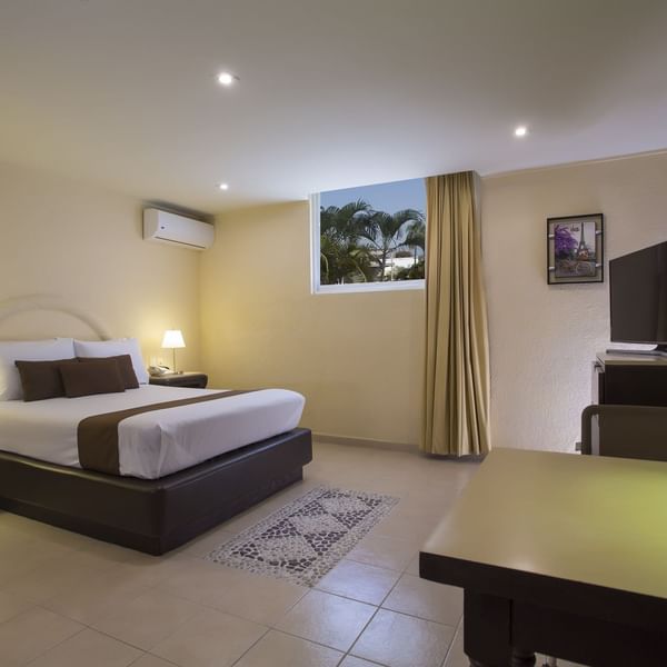 Large bed, TV & desk in the Superior Room at Gamma Hotels