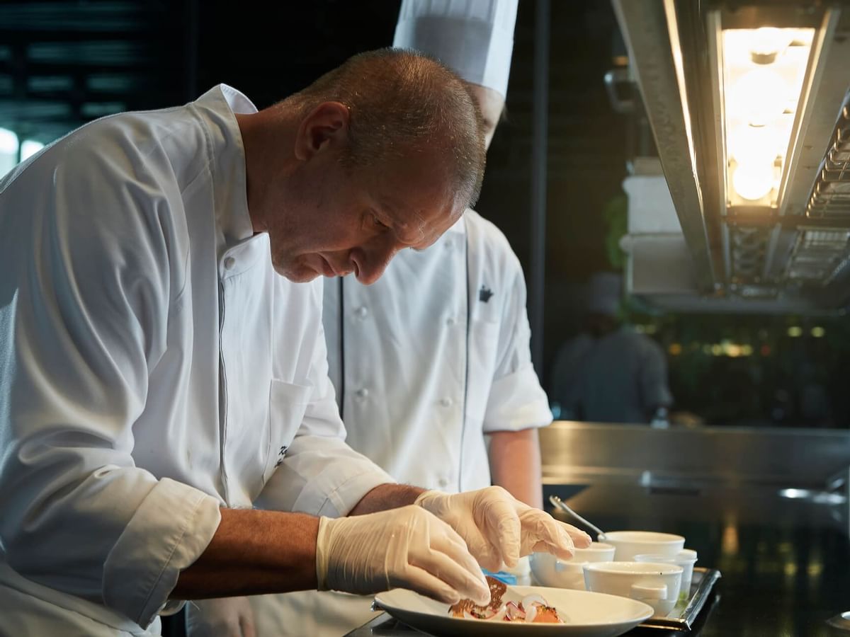 Chef garnishing a dish in Evergreen at Crown Hotel Melbourne