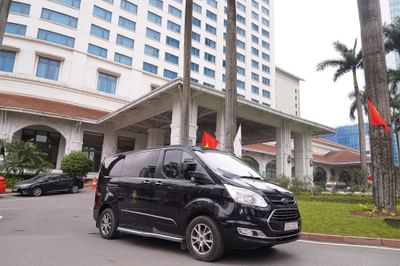A black van parked in front of a Hanoi Daewoo Hotel