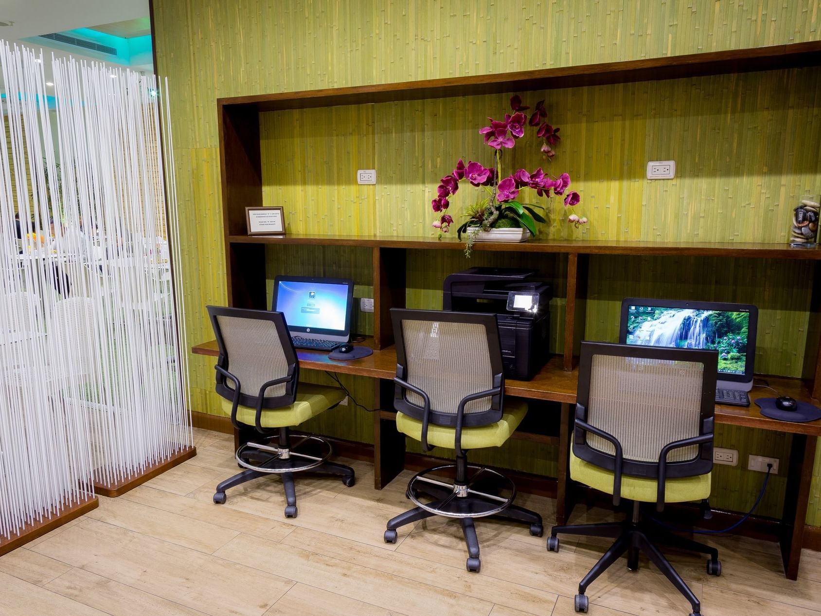 An office with three chairs and a table with computers