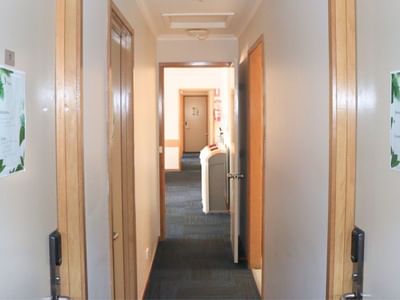 Hallway view with doors and tropical decor posters at La Trobe University Terraces.