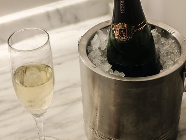 Champagne placed in a silver ice bucket with a glass at La Galerie Hotel