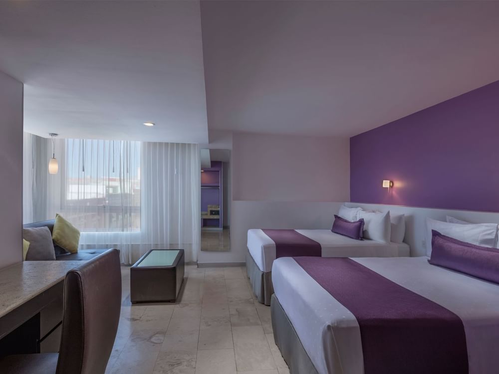 Two comfy beds with working area and seating at Junior Suite Double at Gamma Hotels