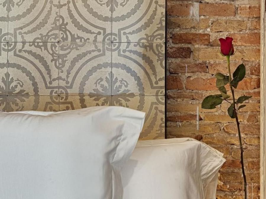 Closeup on bedroom pillows & flowers at Barcelona Apartments