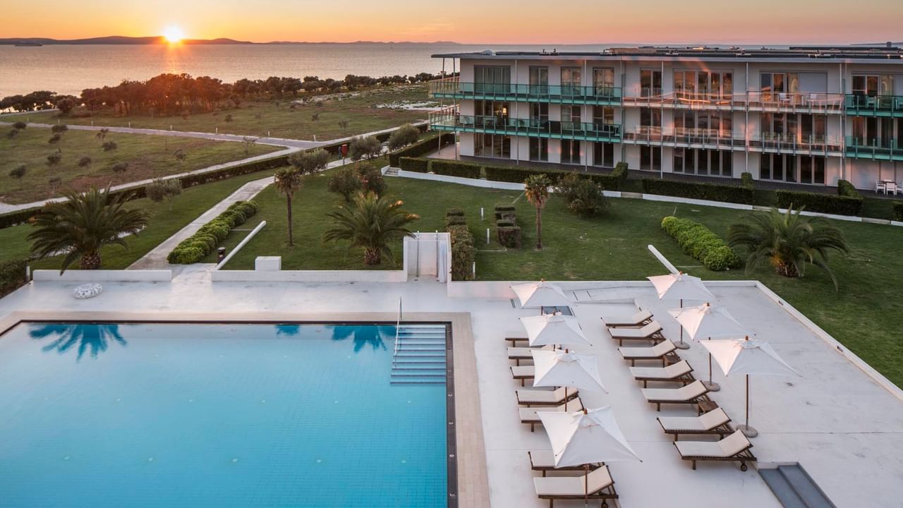 Falkensteiner Premium Apartments with a pool area at sunset