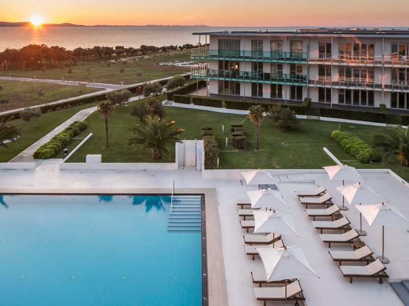 Falkensteiner Premium Apartments with a pool area at sunset