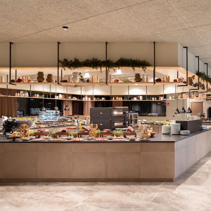 Buffet mit vielen Speisen und Getränken, darunter Fleisch, Salate, Brot und Desserts.