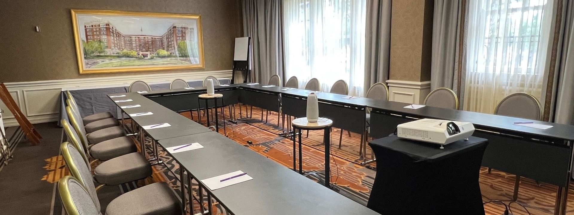 Cedar Springs features U-shaped desks with grey chairs under a projector at Warwick Melrose Dallas