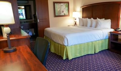 Bed and Work Desk in Deluxe King Room at Rosen Inn International