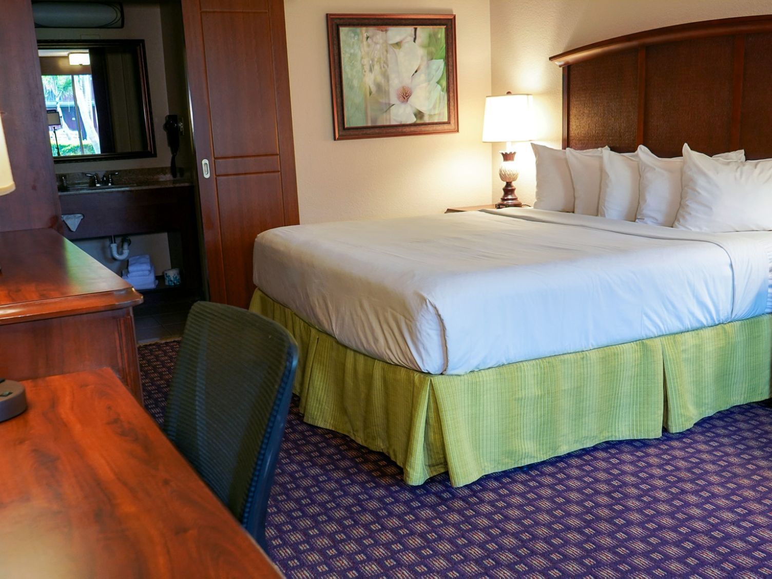 Bed & work desk in Deluxe King Room at Rosen Inn International