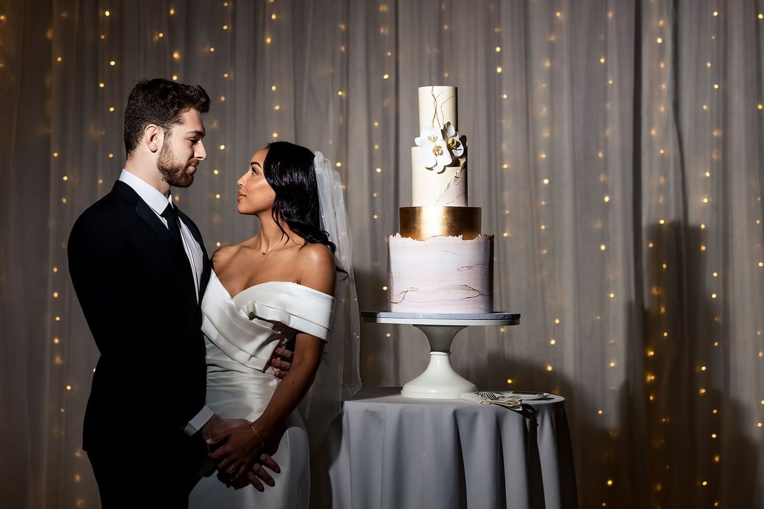A wedding couple beside the Wedding cake table at The Artisan