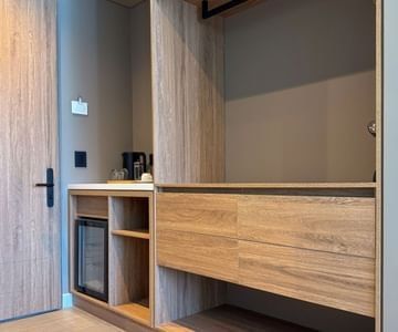Wooden wardrobe and minibar with a compact fridge by the entrance at Unika Hotels, fine for the best area to stay in Bogota
