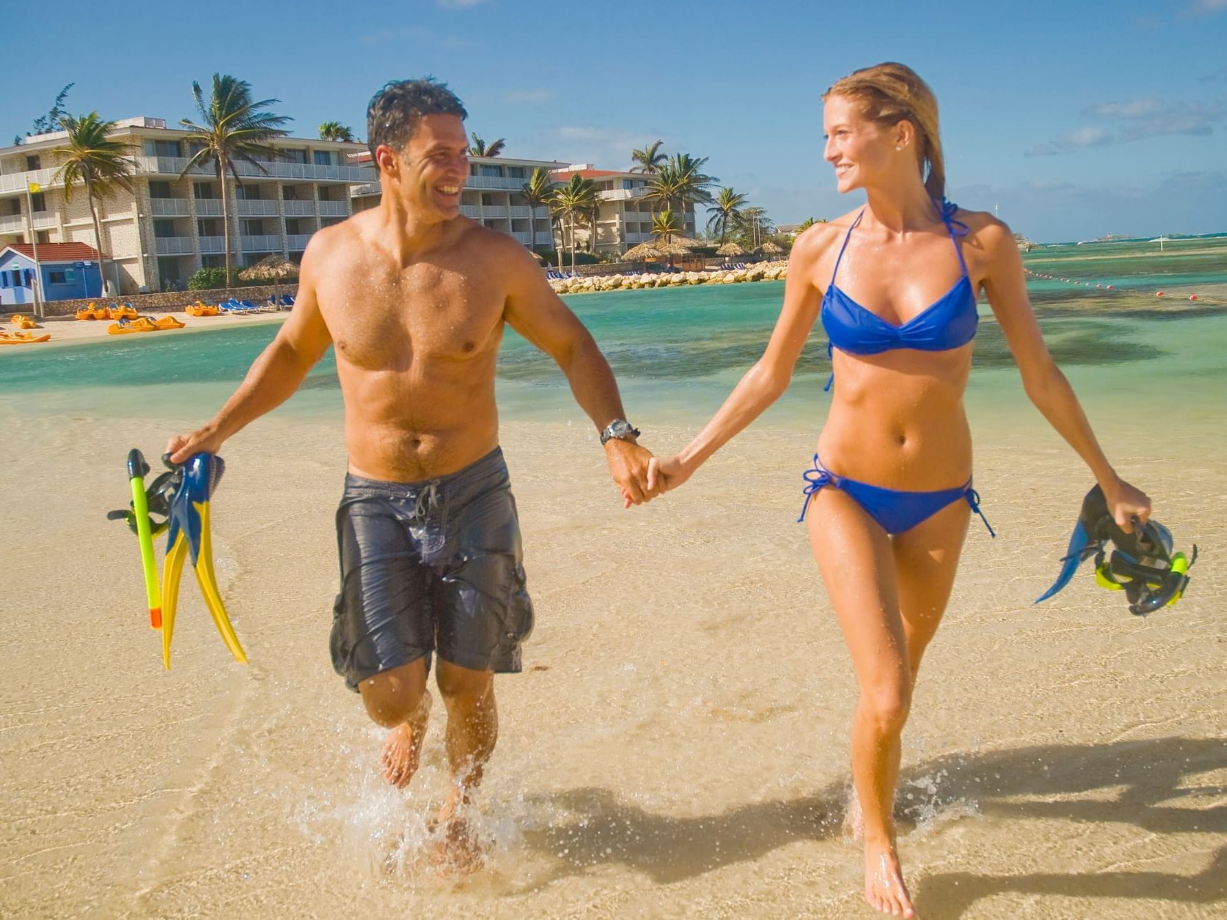 Couple holding hands with snorkeling equipment on a sunny day at Holiday Inn Montego Bay