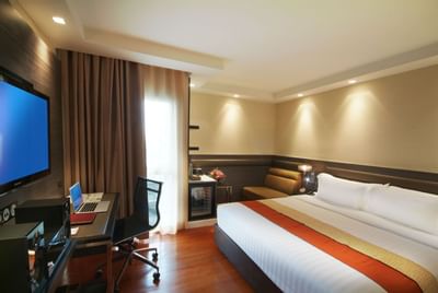 Comfy bed & working desk in Neo Superior room at Amora Neoluxe Hotel Bangkok