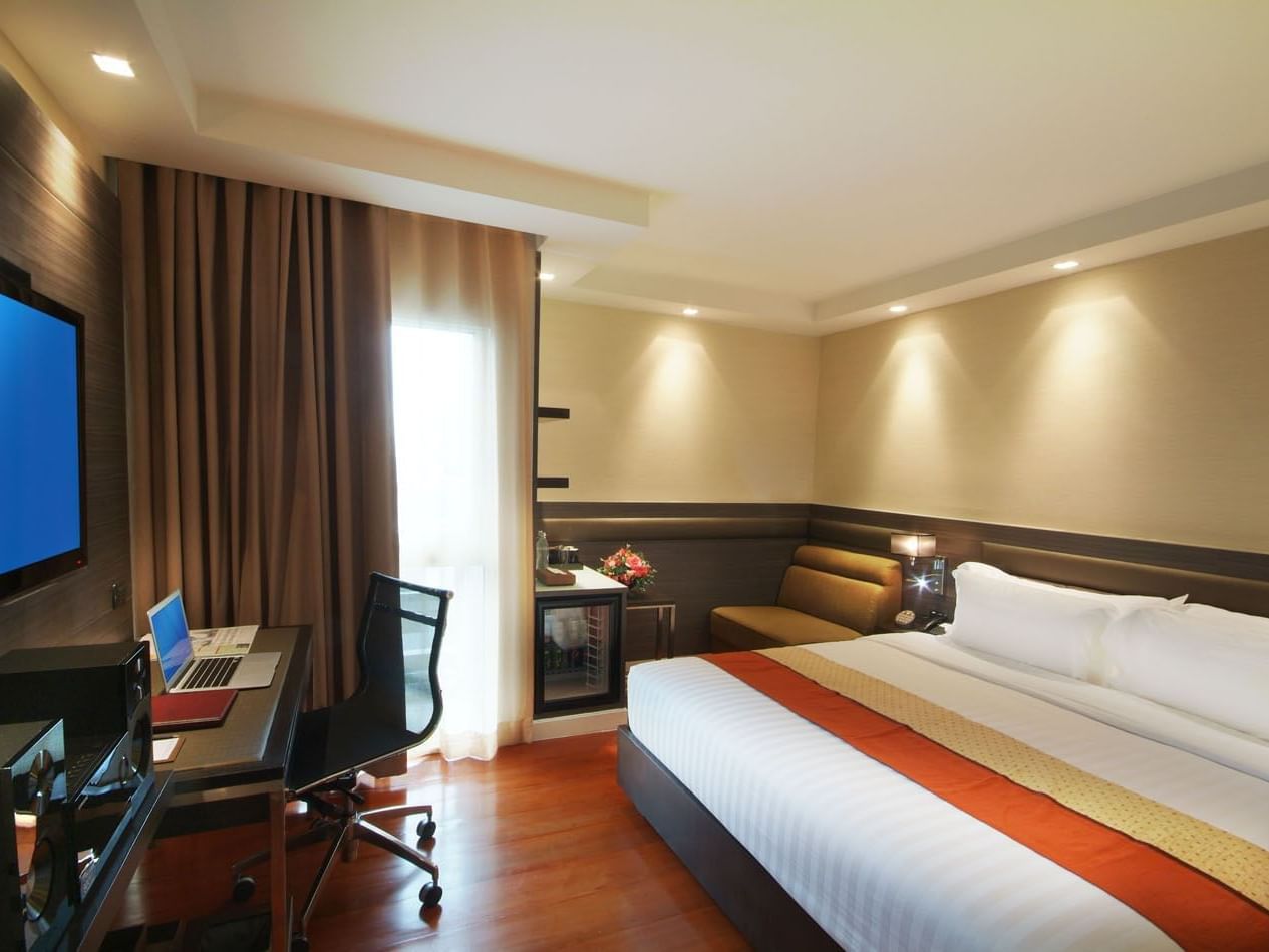 Bed & working desk in Neo Superior room at Amora Hotel