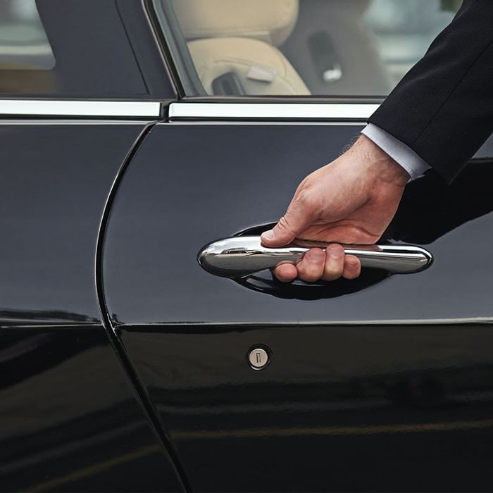 A man hand holding car door handle Falkensteiner Hotels