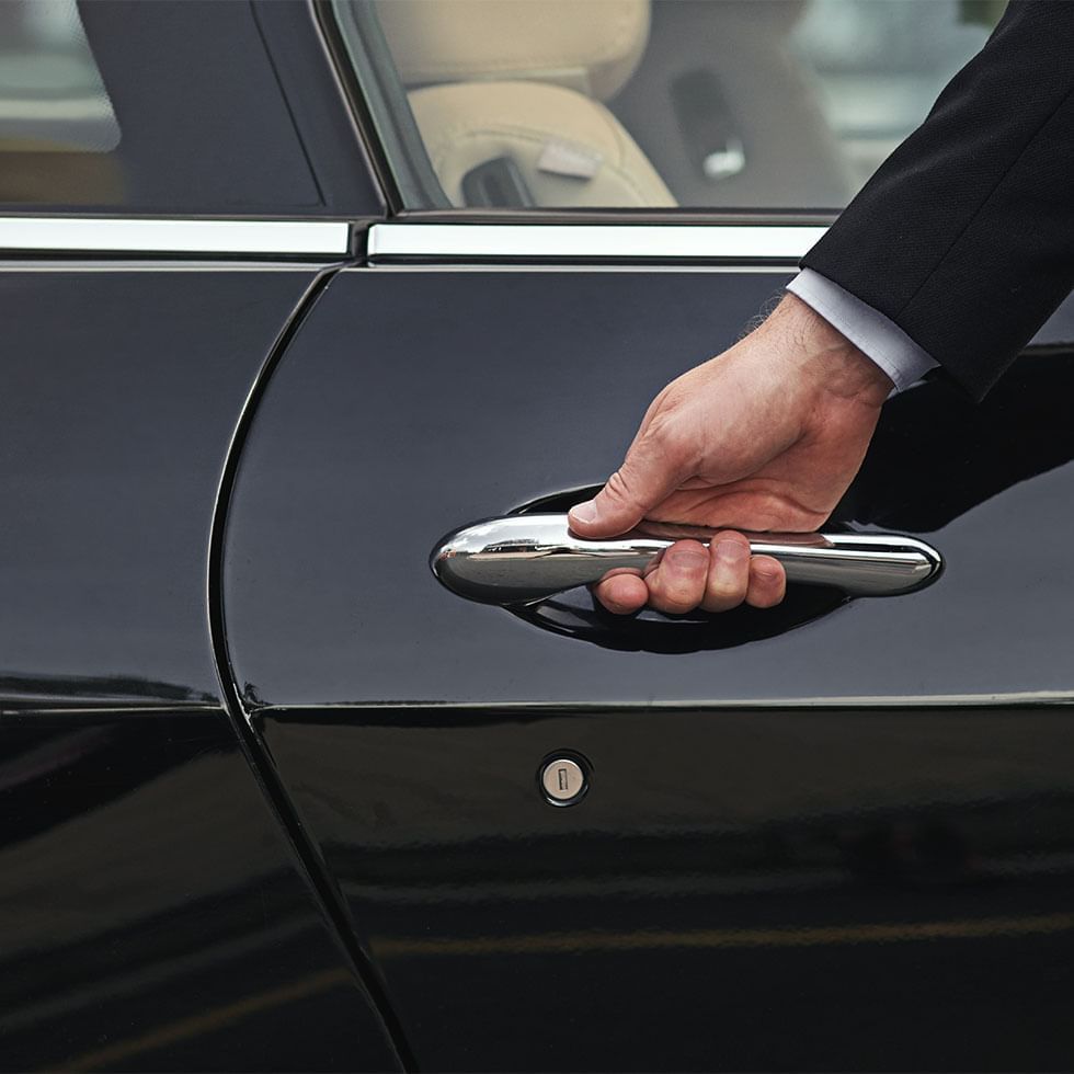 Close-up of a concierge opening the car door at Falkensteiner Schlosshotel Velden
