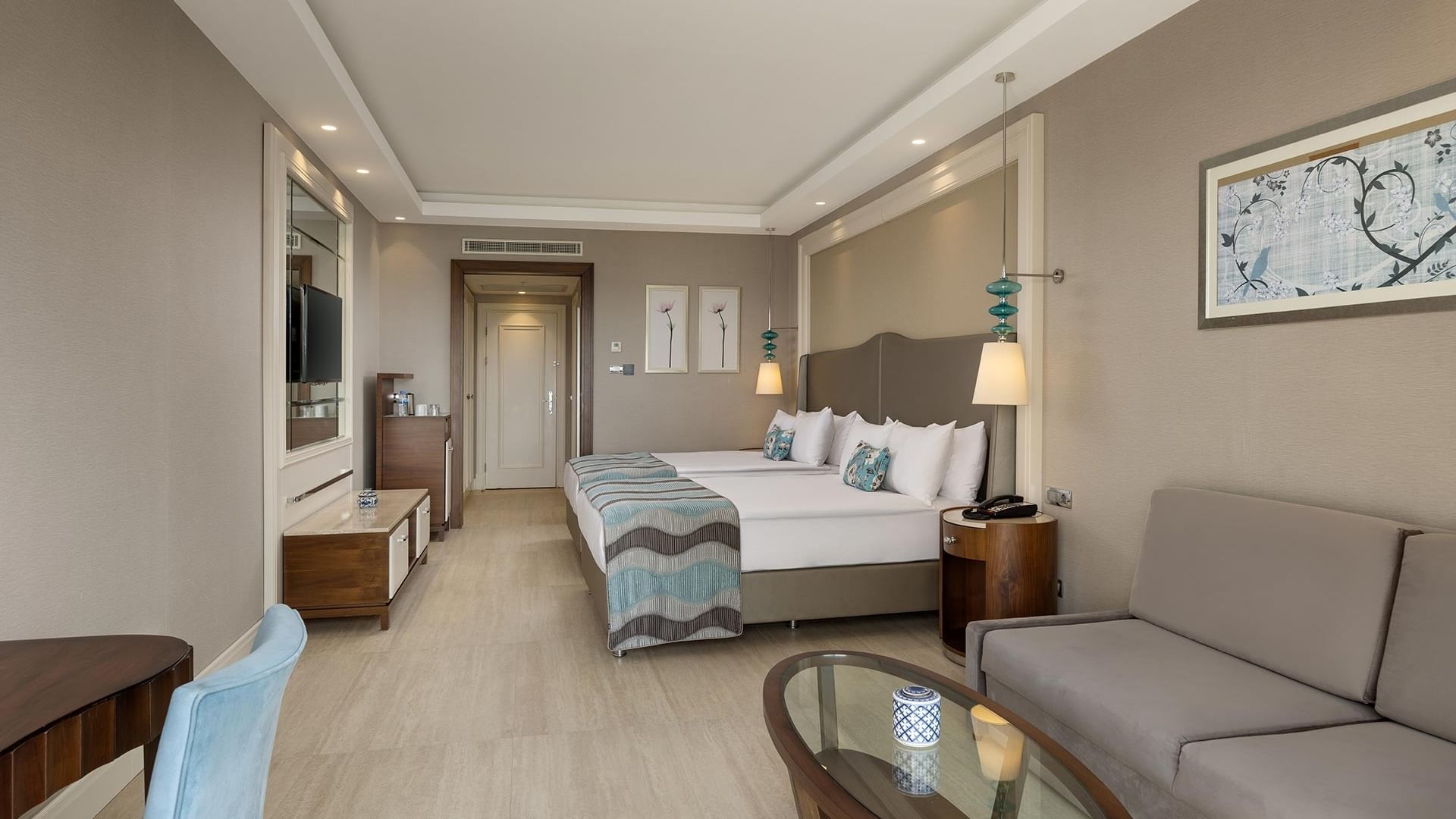 Superior oda ve oturma alanı görünen lüks otel odası Titanic Deluxe Golf Belek, Antalya.
