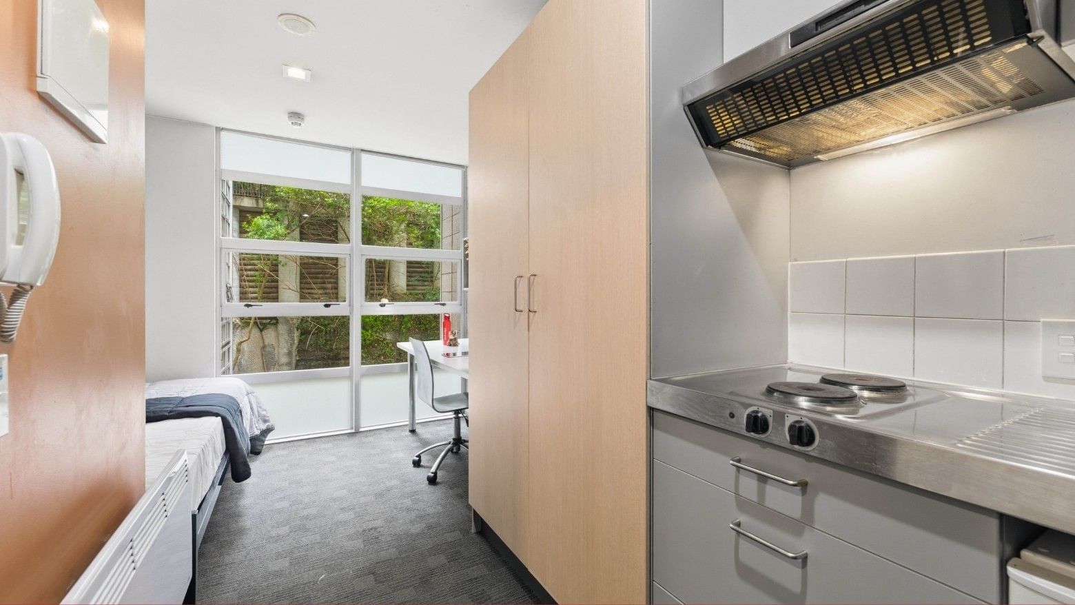 A modern student room at Student Living Auckland Beach with kitchen and desk.