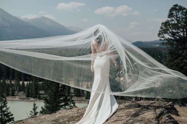 Bride posing on rock with view of mountains