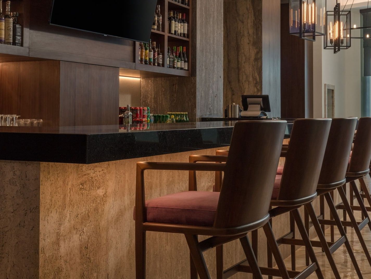 Sleek Lobby Bar showing dark wood accents, elegant bar stools, and warm ambient lighting at Camino Real Merida