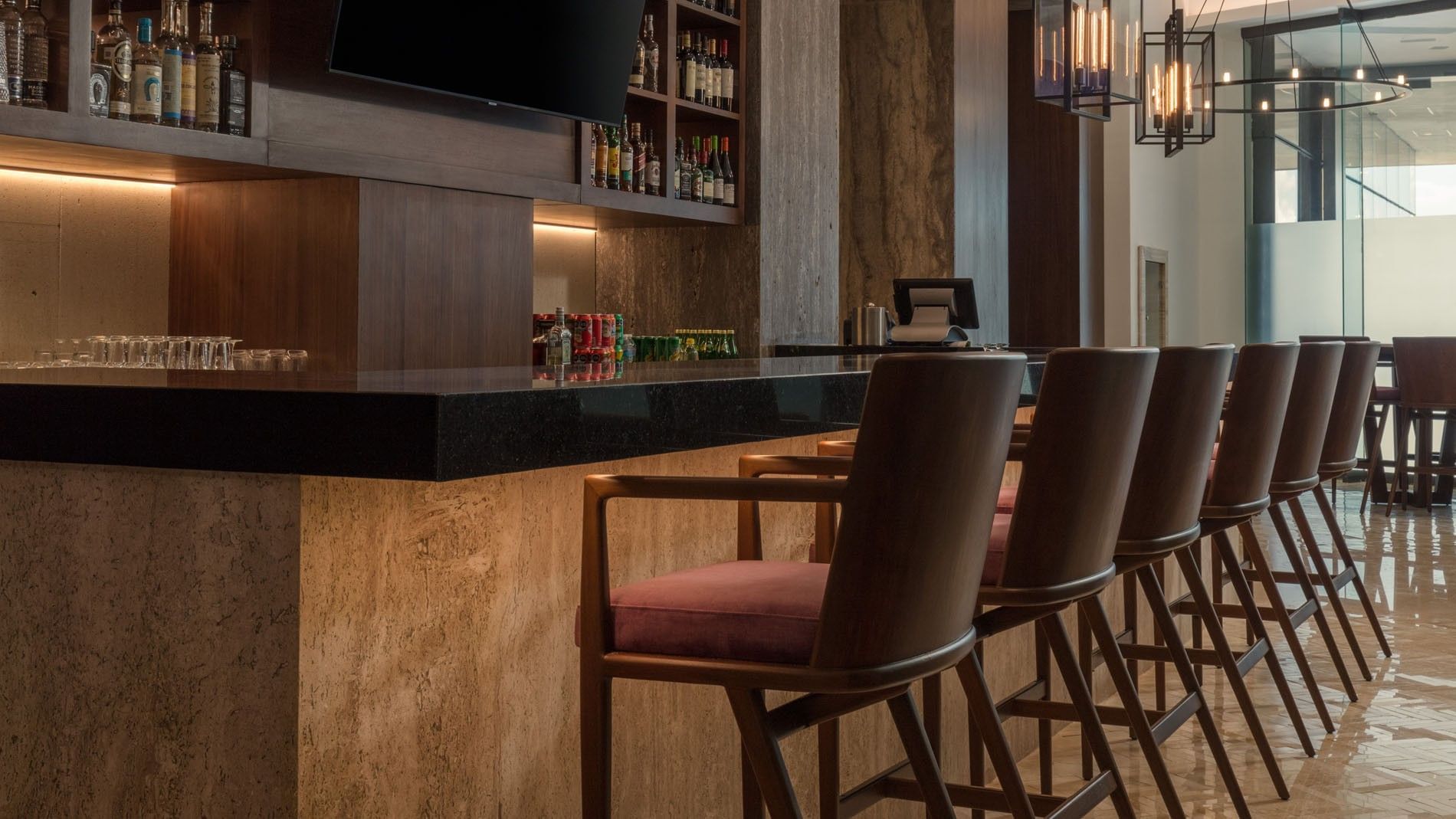 Sleek Lobby Bar showing dark wood accents, elegant bar stools, and warm ambient lighting at Camino Real Merida