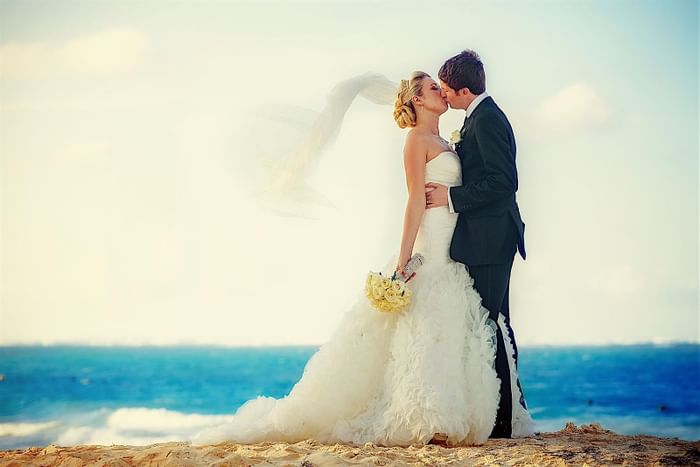 Wedded couple posing by the beach, featuring Dream beach wedding in Barbados at Accra Beach Hotel & Spa