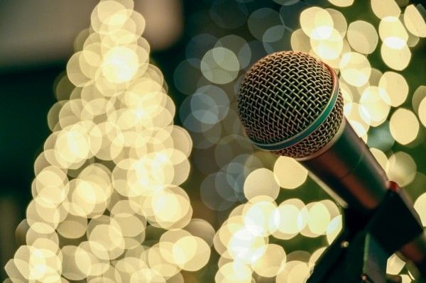 A microphone displayed in front of dazzling Christmas trees.