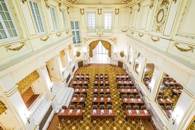 Royal Looking Meeting Room with rows of wooden desks and white chairs arranged at Polonia Palace Hotel