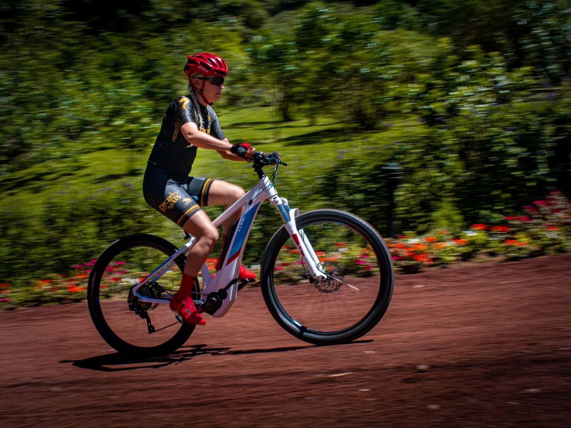 Cyclist in motion on a dirt path with greenery at El Silencio Lodge and Spa