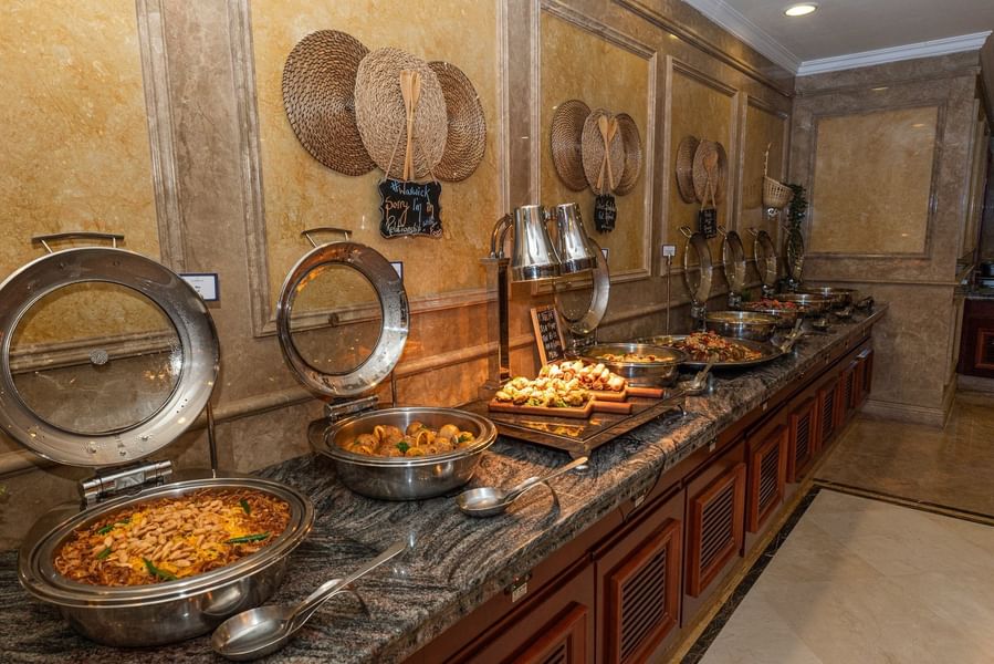 بوفيه طعام فاخر مع أطباق متنوعة وديكورات جدارية من الخوص في Warwick Doha