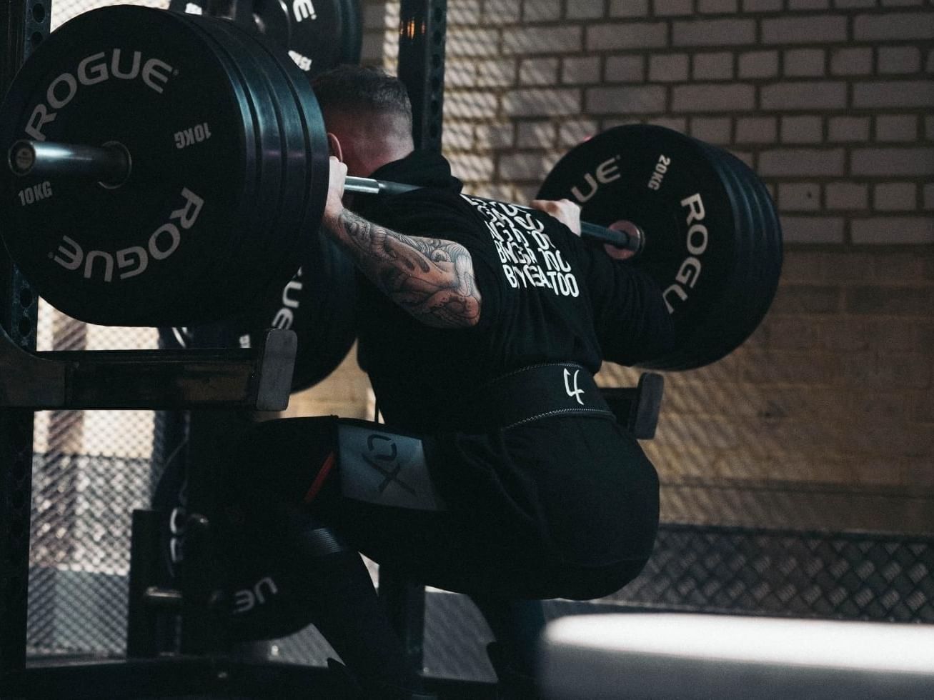 Rear view of a man lifting a barbell at East Park Gym