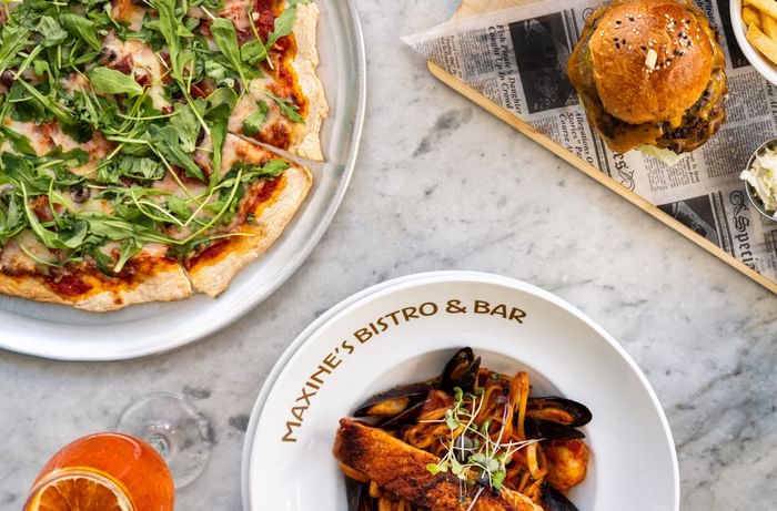 Gourmet pasta and pizza from Maxine's Bistro & Bar near Riviera Hotel South Beach presented in a sleek flat lay