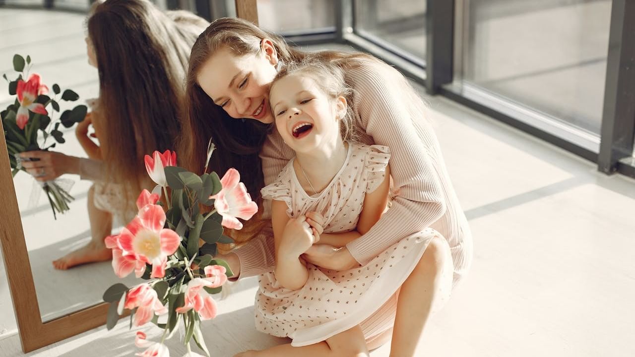 Mother and daughter laughing with flowers.