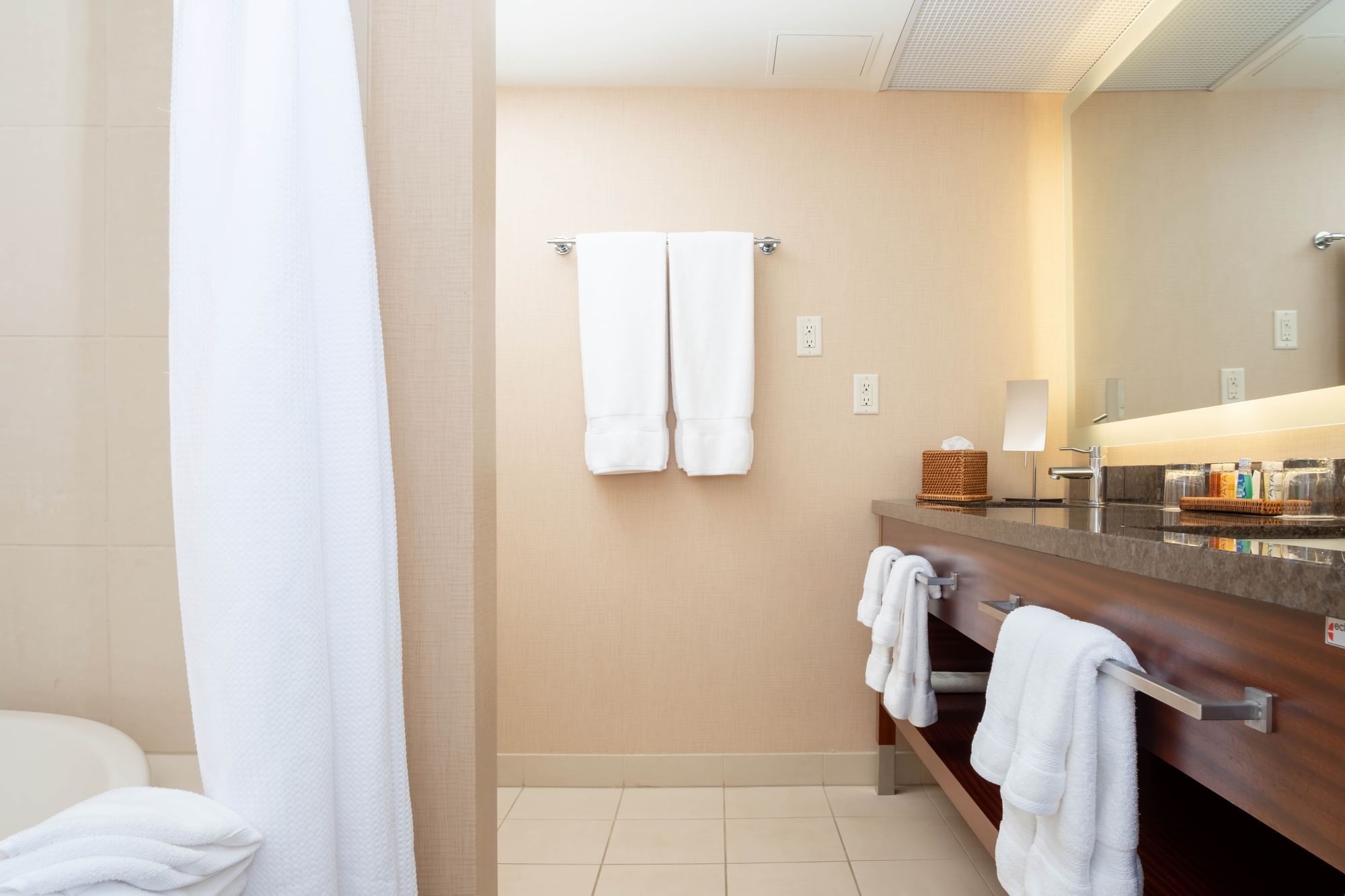 A bathroom with a sink, mirror, and towels