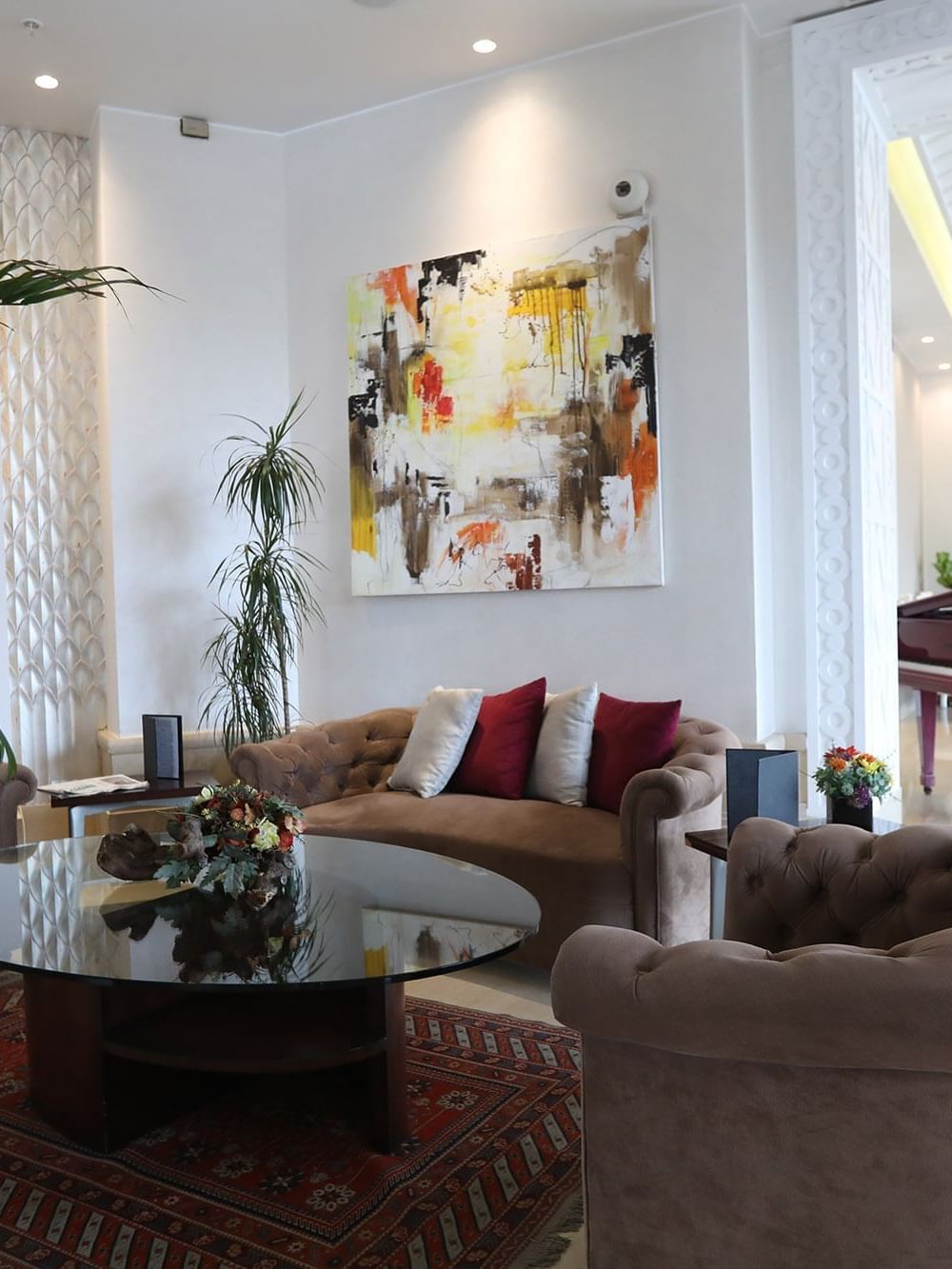 Comfy loungers beneath artwork beside a piano in the Lobby Area at Warwick Palm Beach Hotel